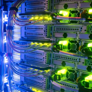 Racks with server equipment are in the dark room of the data center. Colorful indication of the network interests of the Internet router. Information Technology Concept.