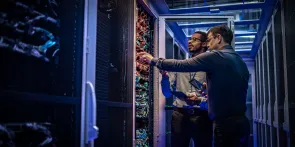 Ingenieros de TI comprobando servidores en la sala de servidores
